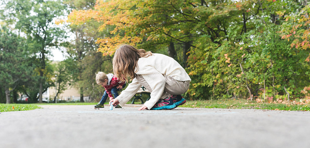 Kids draw with chalk on the sidewalk by Sarah Pflug