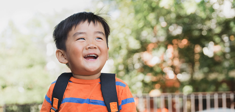 School child giggling in the sun by Sarah Pflug